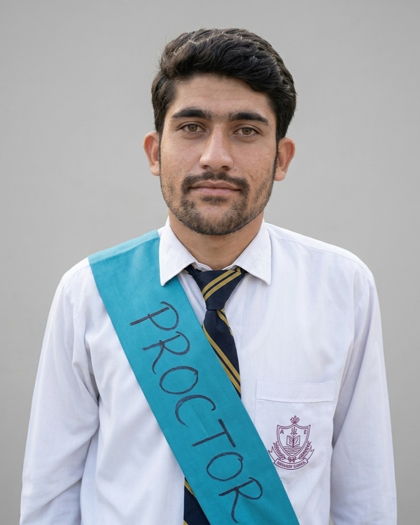Scholarship winner in school uniform with a blue proctor sash, studio portrait